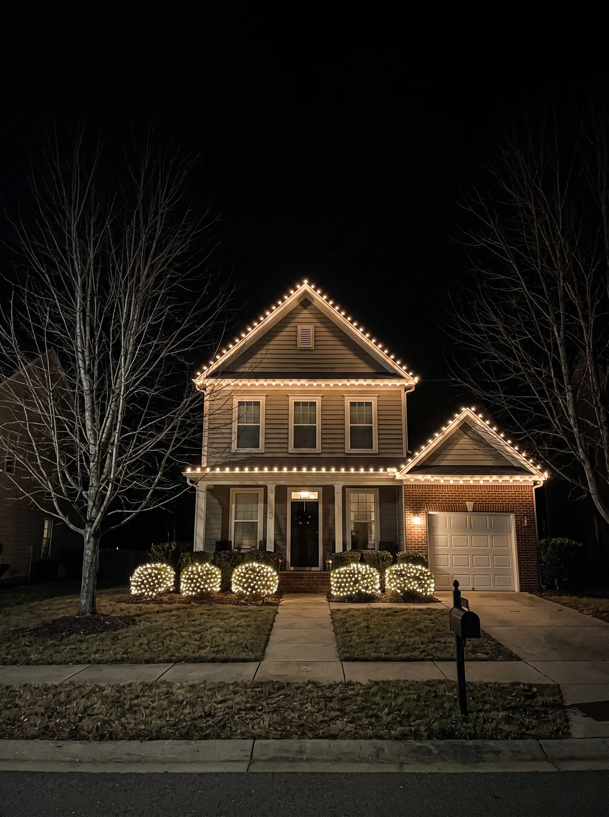 Two-story home with warm-white C9 eaves and gable