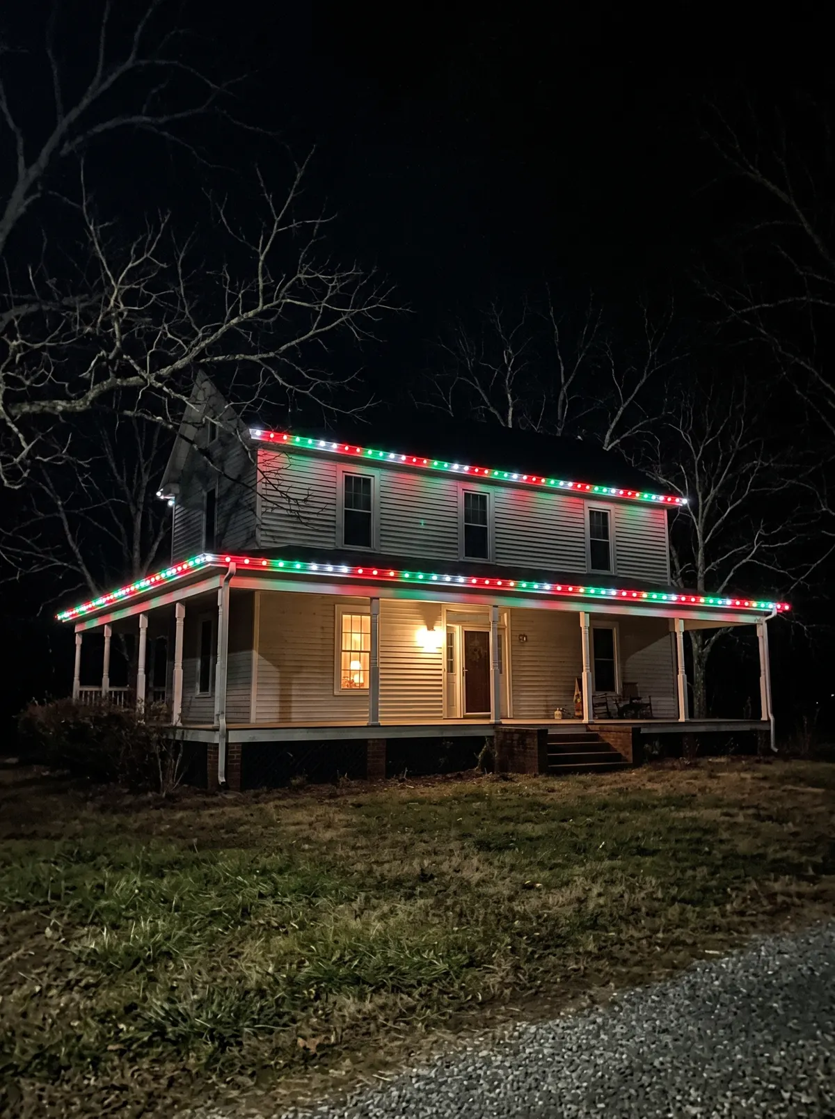 Farmhouse with red, green and white C9 on the wraparound porch